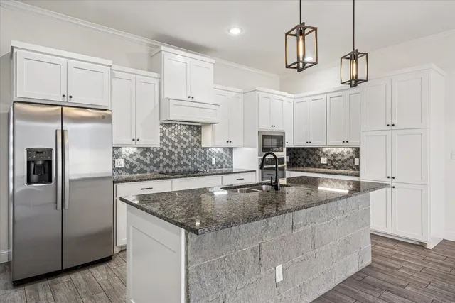 a kitchen with kitchen island a counter top space appliances and cabinets