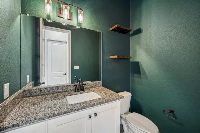 a large kitchen with granite countertop a white stove top oven and cabinets