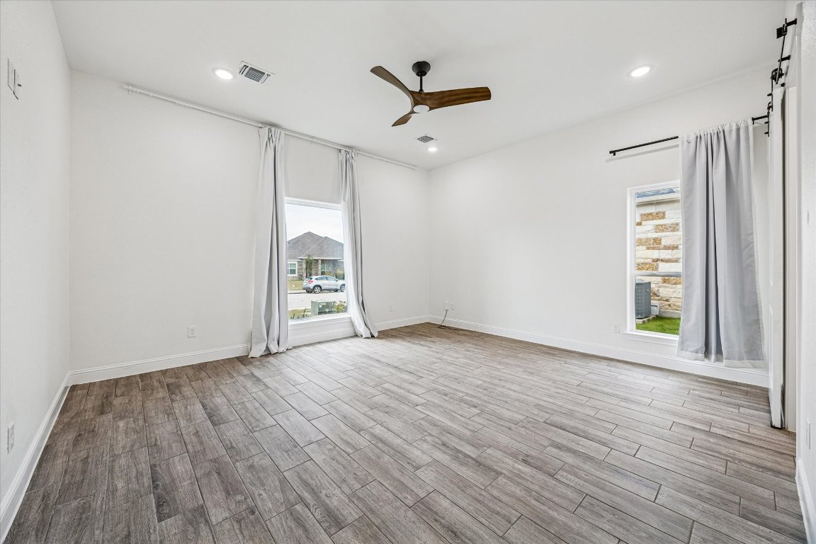 136 Greg Lane Jarrell, TX 76537 - Photo 5 of 10 a view of an empty room with a window and wooden floor