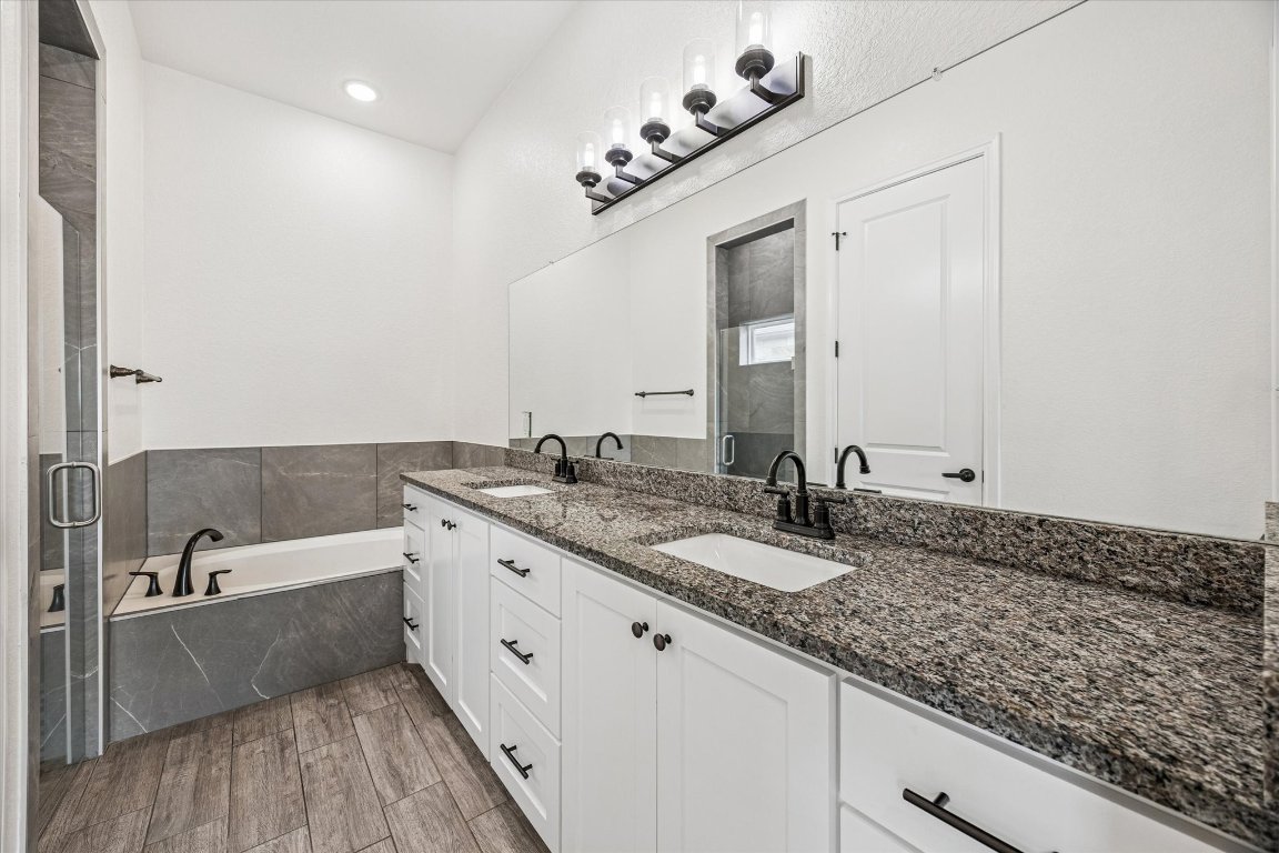 136 Greg Lane Jarrell, TX 76537 - Photo 6 of 10 a bathroom with a granite countertop bathtub sink vanity and mirror