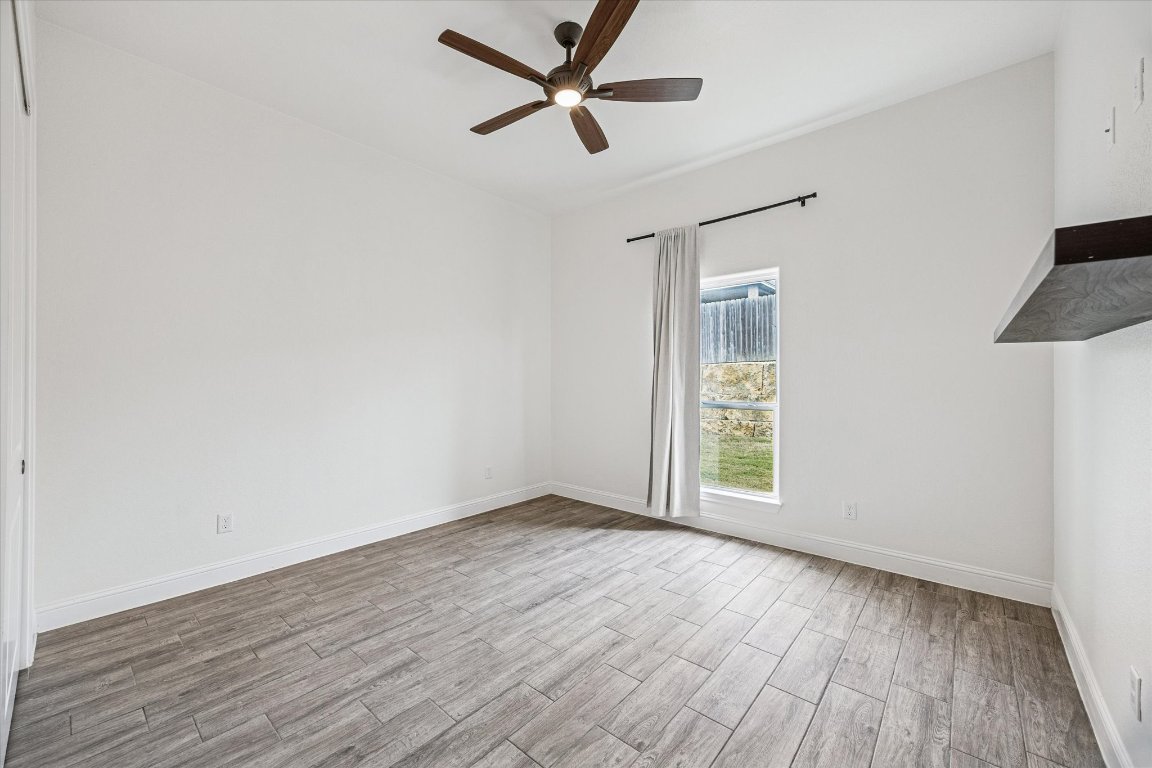 136 Greg Lane Jarrell, TX 76537 - Photo 7 of 10 an empty room with wooden floor and windows