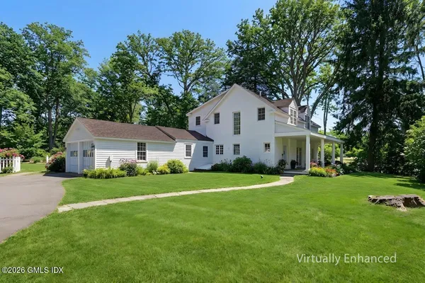 a front view of a house with a yard and trees