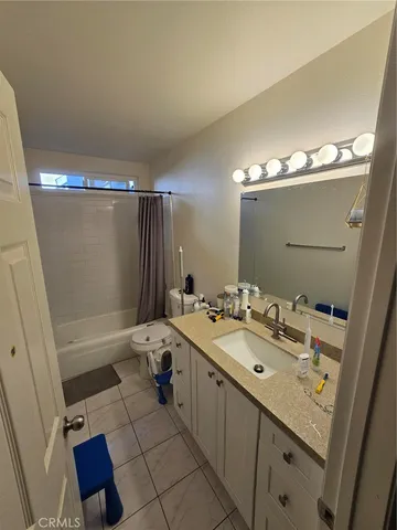a spacious bathroom with a double vanity sink toilet mirror and shower