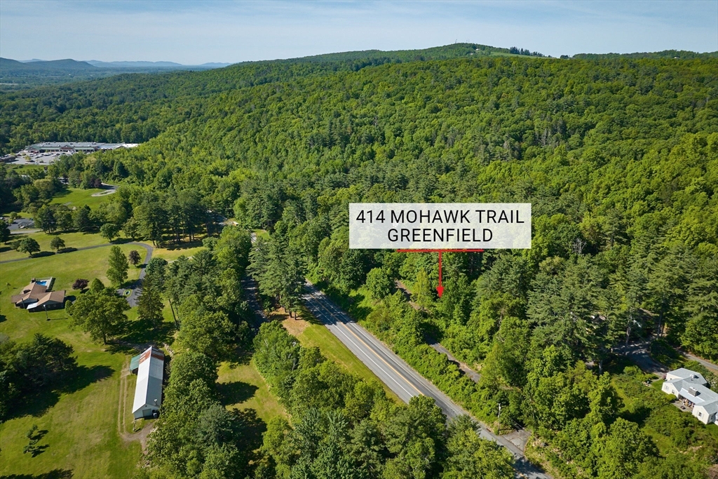 414 Mohawk Trail Greenfield, MA 01301 - Photo 2 of 10 a sign that is sitting on a lush green field