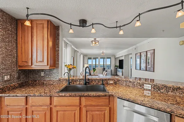 a kitchen with stainless steel appliances granite countertop a stove top oven a sink a stove and a refrigerator