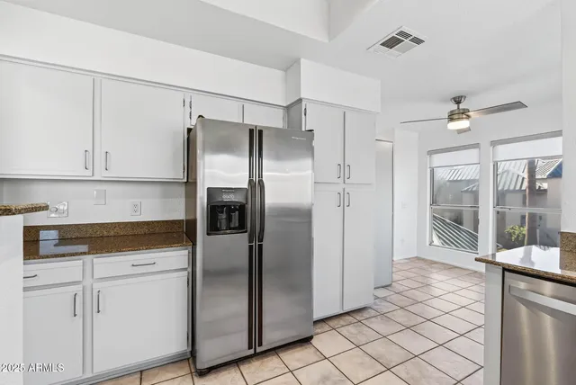 a kitchen with granite countertop white cabinets and stainless steel appliances