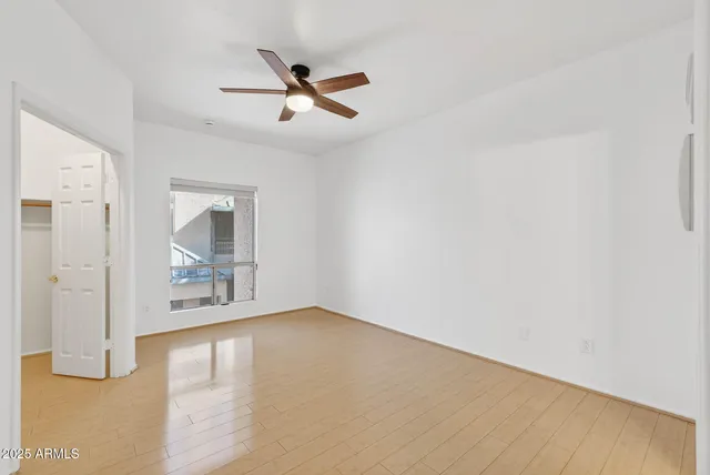 a view of a big room with wooden floor and a ceiling fan