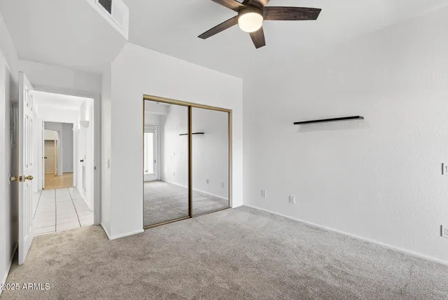 an empty room with fan and windows