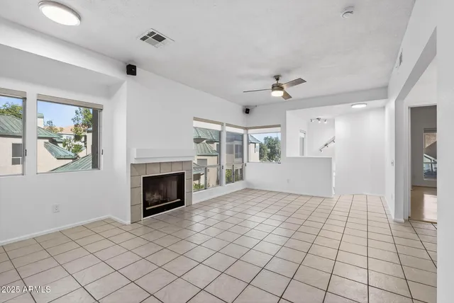 a view of empty room with fireplace and windows