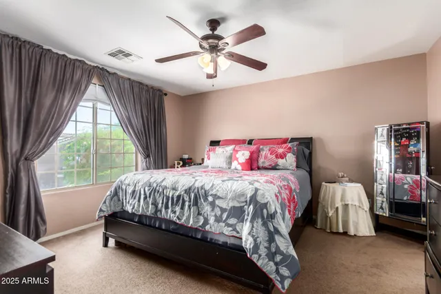 a bedroom with a bed and a large window