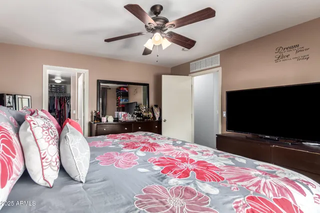 a bedroom with a bed and a flat screen tv