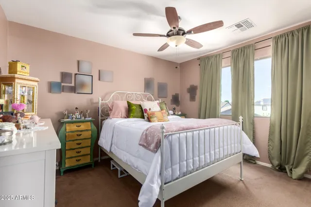 a bedroom with a bed a dresser and a chandelier