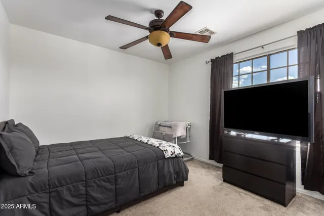 a bedroom with a bed and a flat screen tv