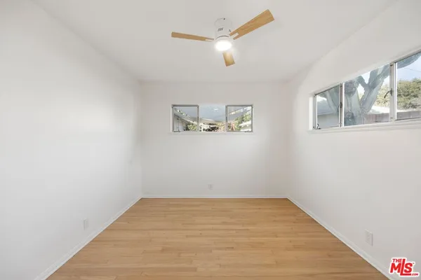 a view of empty room with wooden floor
