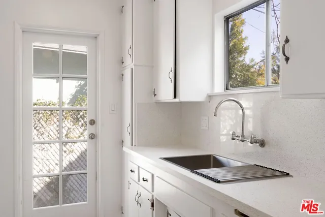 a bathroom with a granite countertop sink and a window