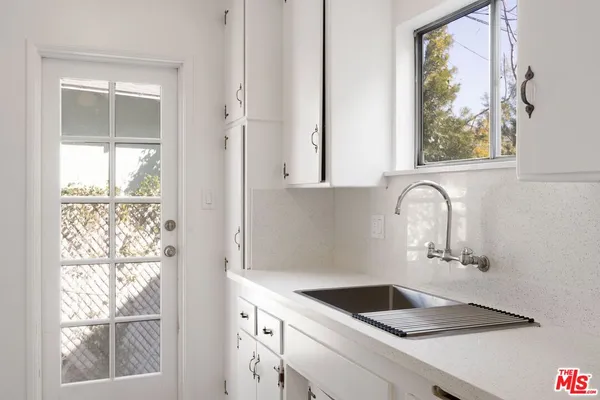 a bathroom with a granite countertop sink and a window