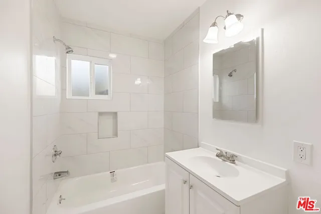 a bathroom with a sink vanity tub and shower