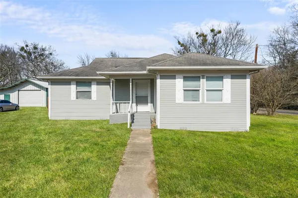 a front view of a house with a garden and yard