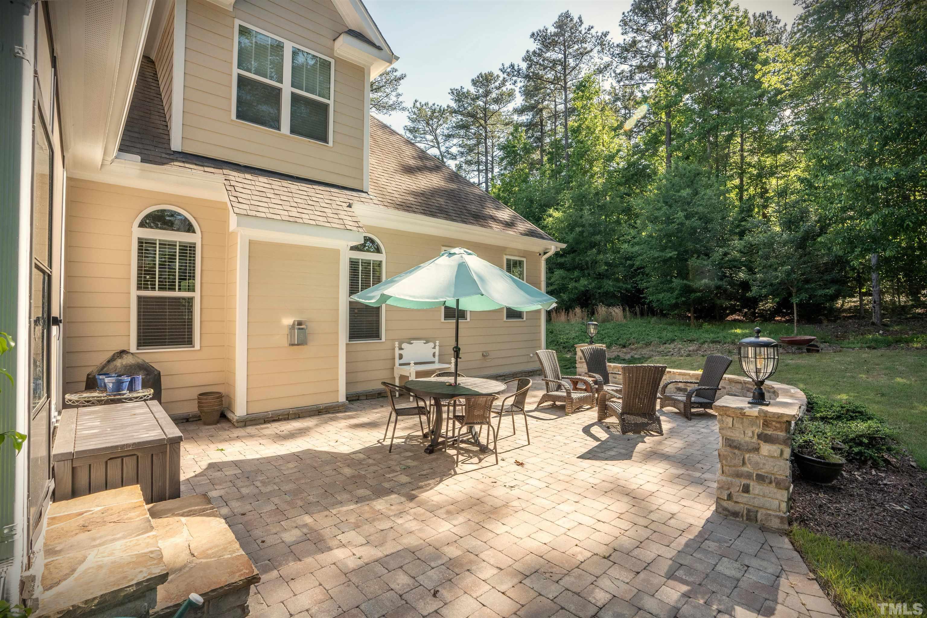 232 Bayleaf Drive Raleigh, NC 27615 - Photo 20 of 26 a view of a patio with table and chairs potted plants and a palm tree