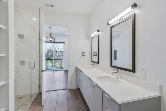 a bathroom with a double vanity sink mirror and shower