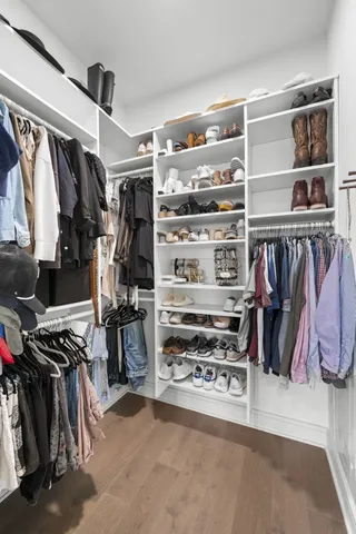 a view of walk in closet with clothes and shoes