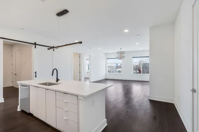 a view of a kitchen with a sink and wooden floor