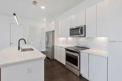 a kitchen with stainless steel appliances granite countertop a stove a sink and a refrigerator