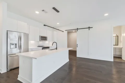 a kitchen with stainless steel appliances a white refrigerator a sink and a refrigerator