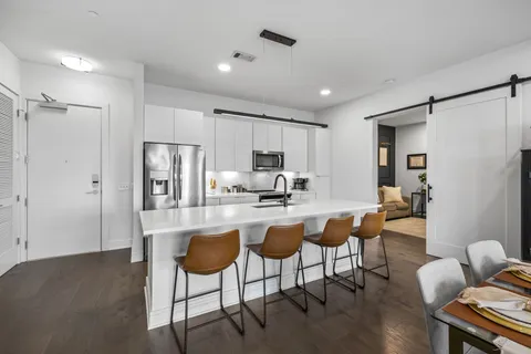 a kitchen with a dining table chairs refrigerator and cabinets