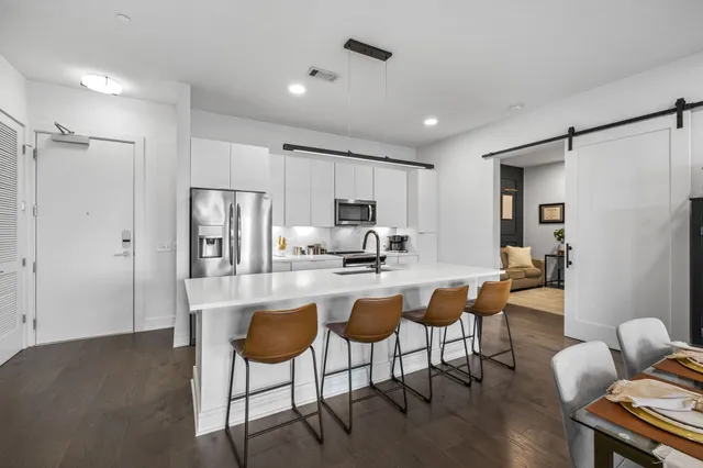 a kitchen with a dining table chairs refrigerator and cabinets