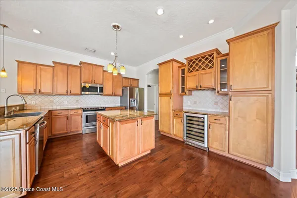 a large kitchen with stainless steel appliances granite countertop a stove a sink dishwasher and a oven with white cabinets