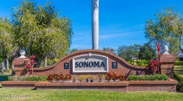 a view of a house with a big yard and palm trees