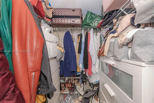 a view of walk in closet with clothes