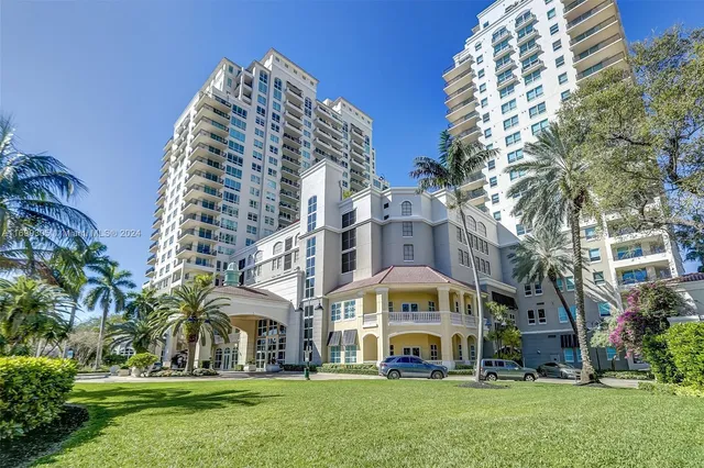 a view of building with glass windows and palm tree
