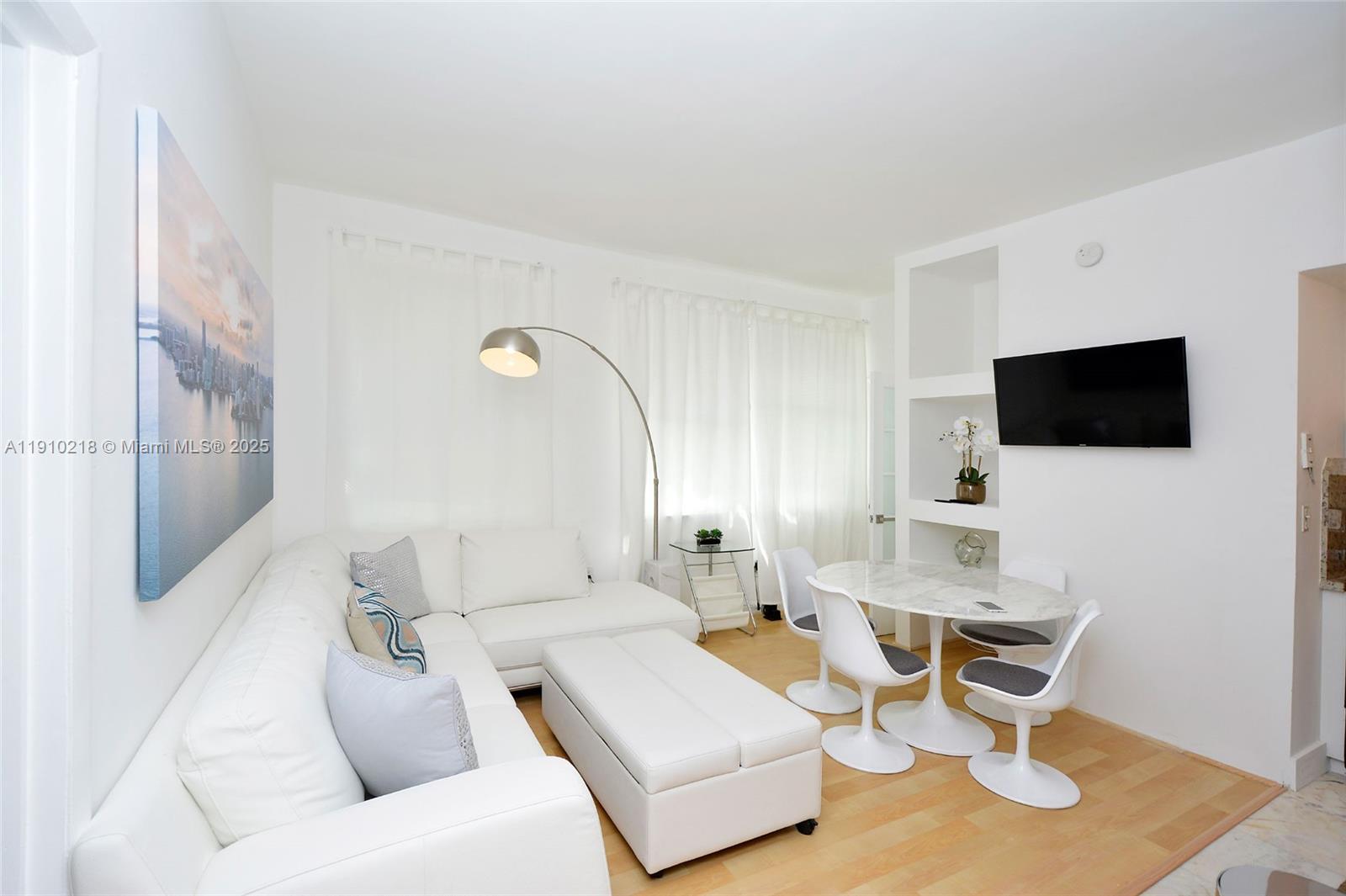 1342 Drexel Avenue, Unit 105 Miami Beach, FL 33139 - Photo 1 of 12 a living room with furniture and a flat screen tv