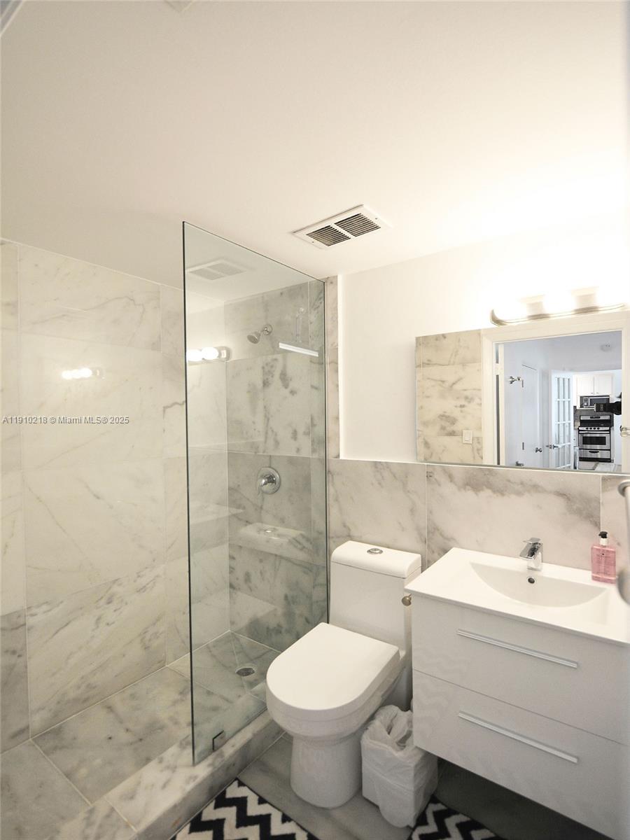 1342 Drexel Avenue, Unit 105 Miami Beach, FL 33139 - Photo 11 of 12 a bathroom with a sink toilet and shower
