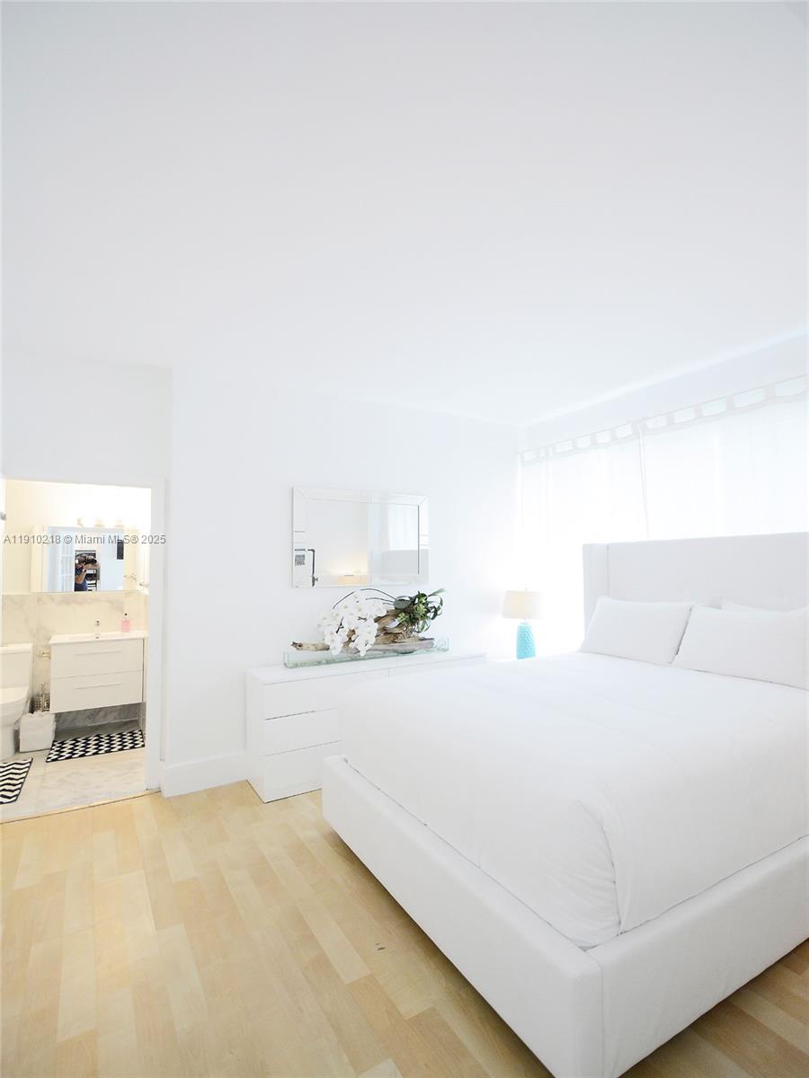 1342 Drexel Avenue, Unit 105 Miami Beach, FL 33139 - Photo 4 of 12 a bedroom with a bed and a couch