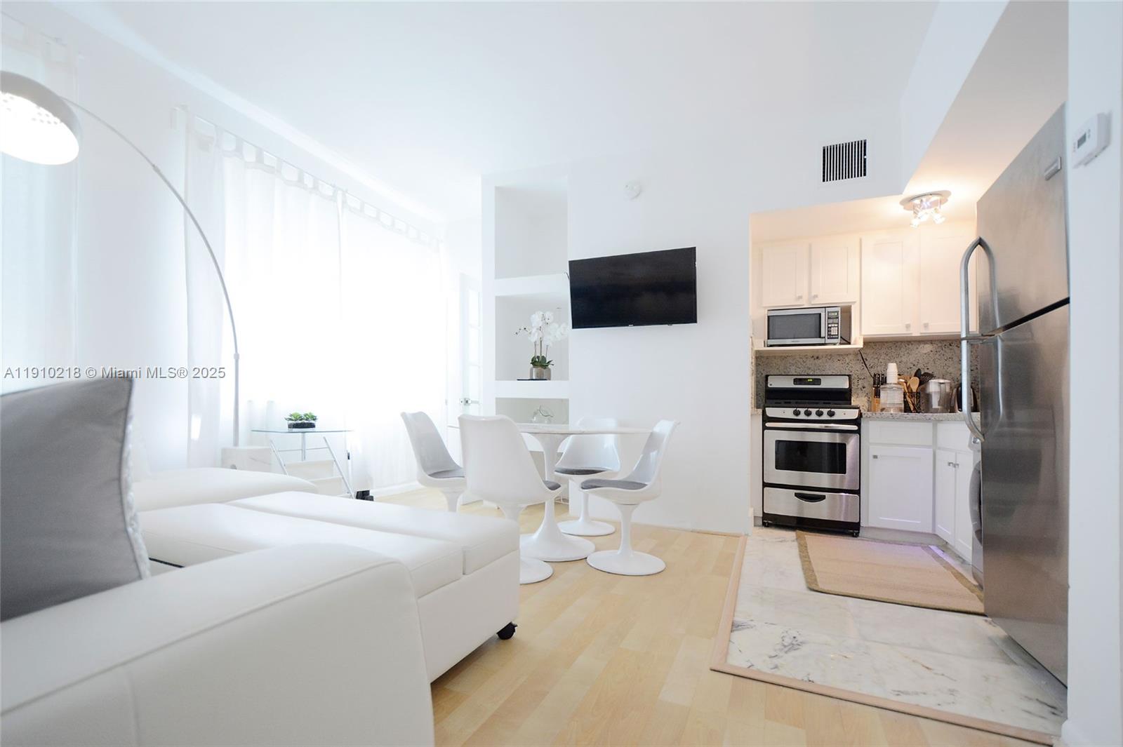 1342 Drexel Avenue, Unit 105 Miami Beach, FL 33139 - Photo 5 of 12 a living room with furniture and a flat screen tv