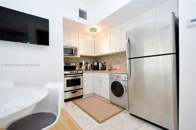a kitchen with a refrigerator a microwave a stove and cabinets
