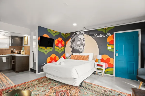 a bedroom with a bed and painting on the wall