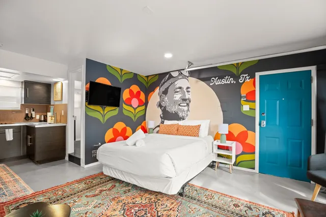 a bedroom with a bed and painting on the wall