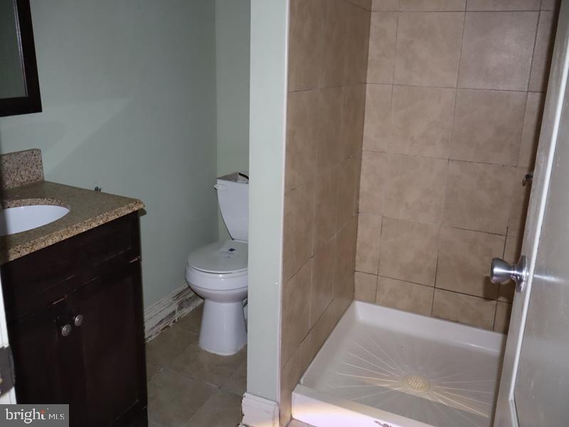 1502 68th Avenue Philadelphia, PA 19126 - Photo 16 of 20 a bathroom with a granite countertop sink toilet and a mirror