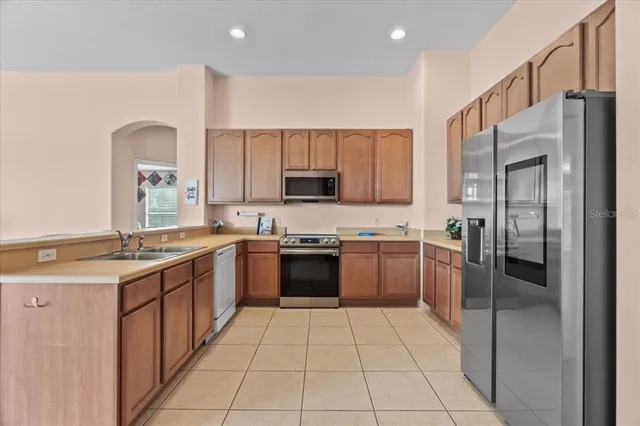 a a kitchen with stainless steel appliances granite countertop a refrigerator and a stove top oven