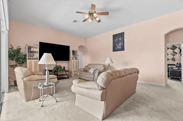 a living room with furniture and a ceiling fan