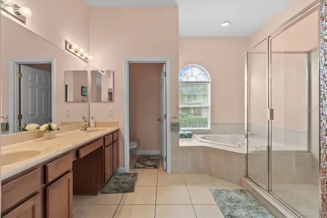 a spacious bathroom with a tub sink and mirror
