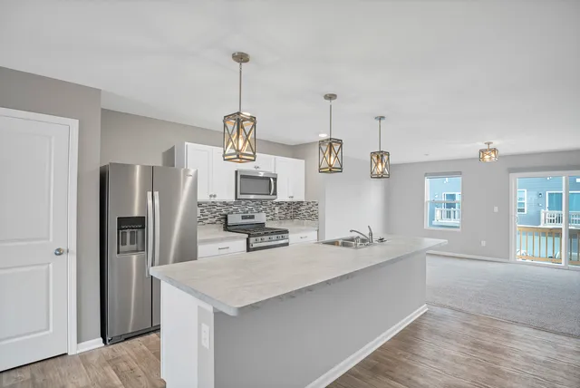a kitchen with stainless steel appliances granite countertop a sink and refrigerator