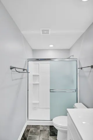 a bathroom with a shower a toilet and a sink