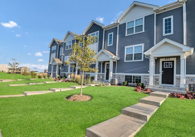 a view of a house with a yard fire pit and a large tree