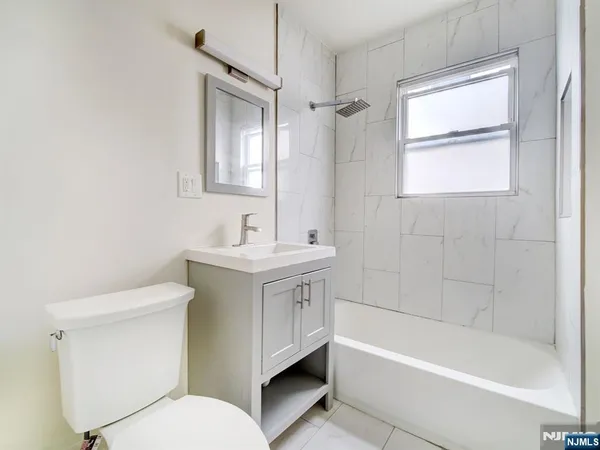 a bathroom with a bathtub toilet sink and mirror
