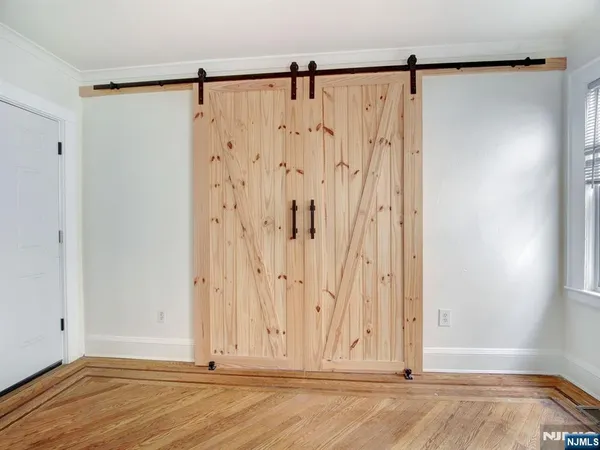 a view of a room with wooden floor and a shower